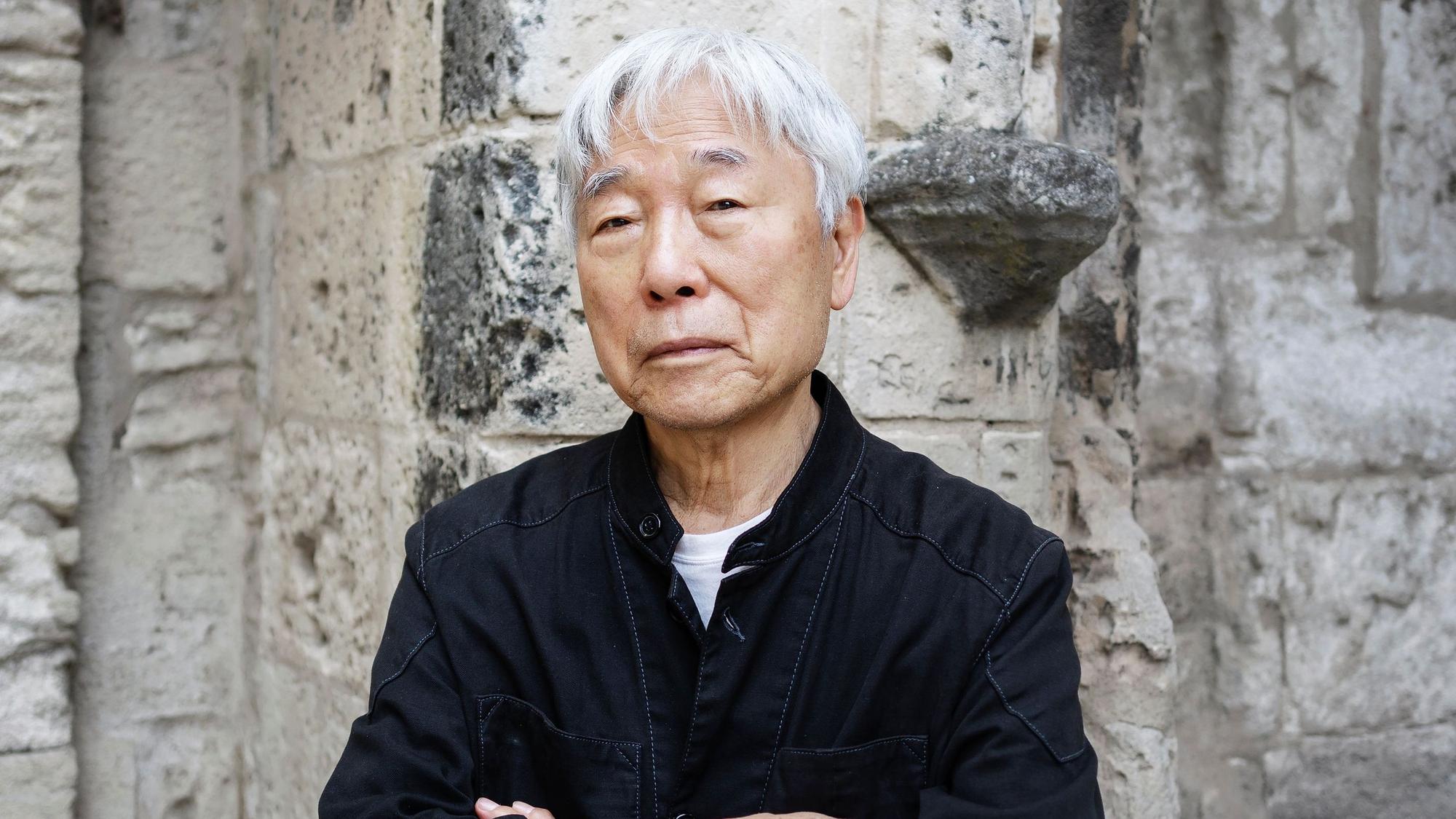 Lee Ufan steht vor einer Mauer.