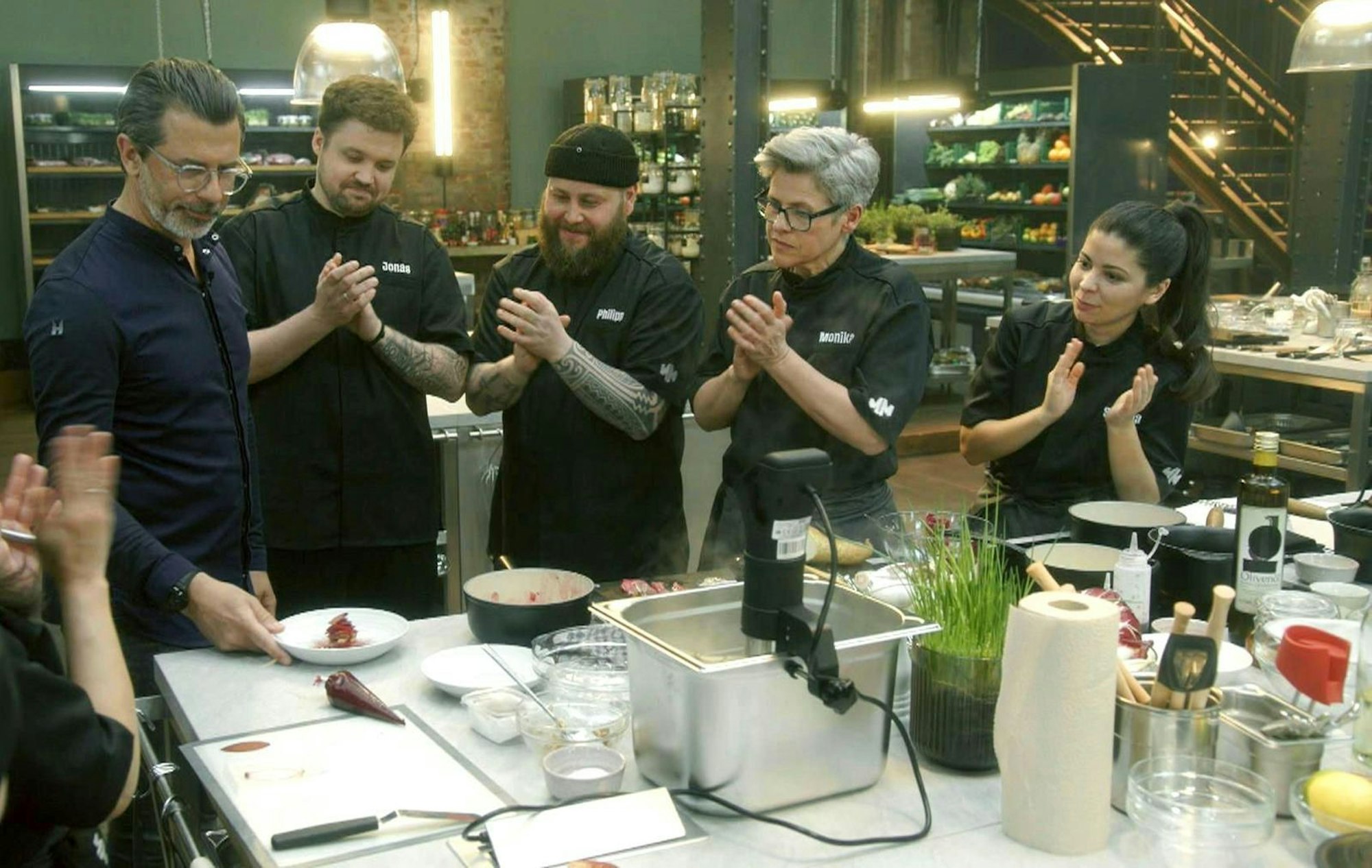 Andreas Caminada (links) begeistert die Kandidaten mit seinen Kochkünsten. (Bild: RTL)
