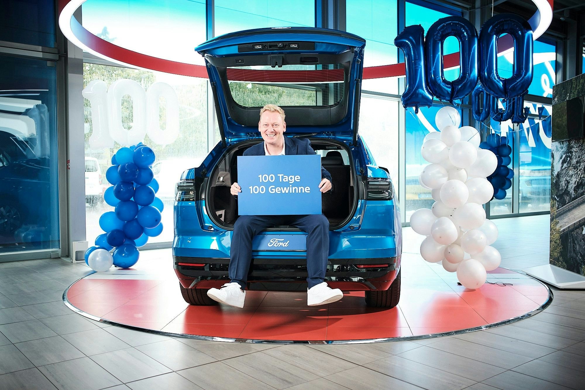 Das Bild zeigt Knossi in einem blauen Ford Wagen.