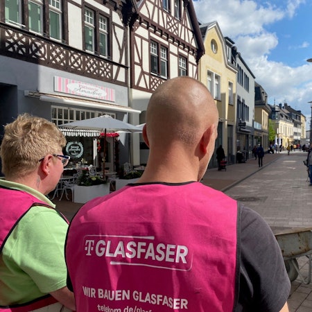Zu sehen sind Arbeiter, die Westen mit der Aufschrift „Glasfaser“ tragen.