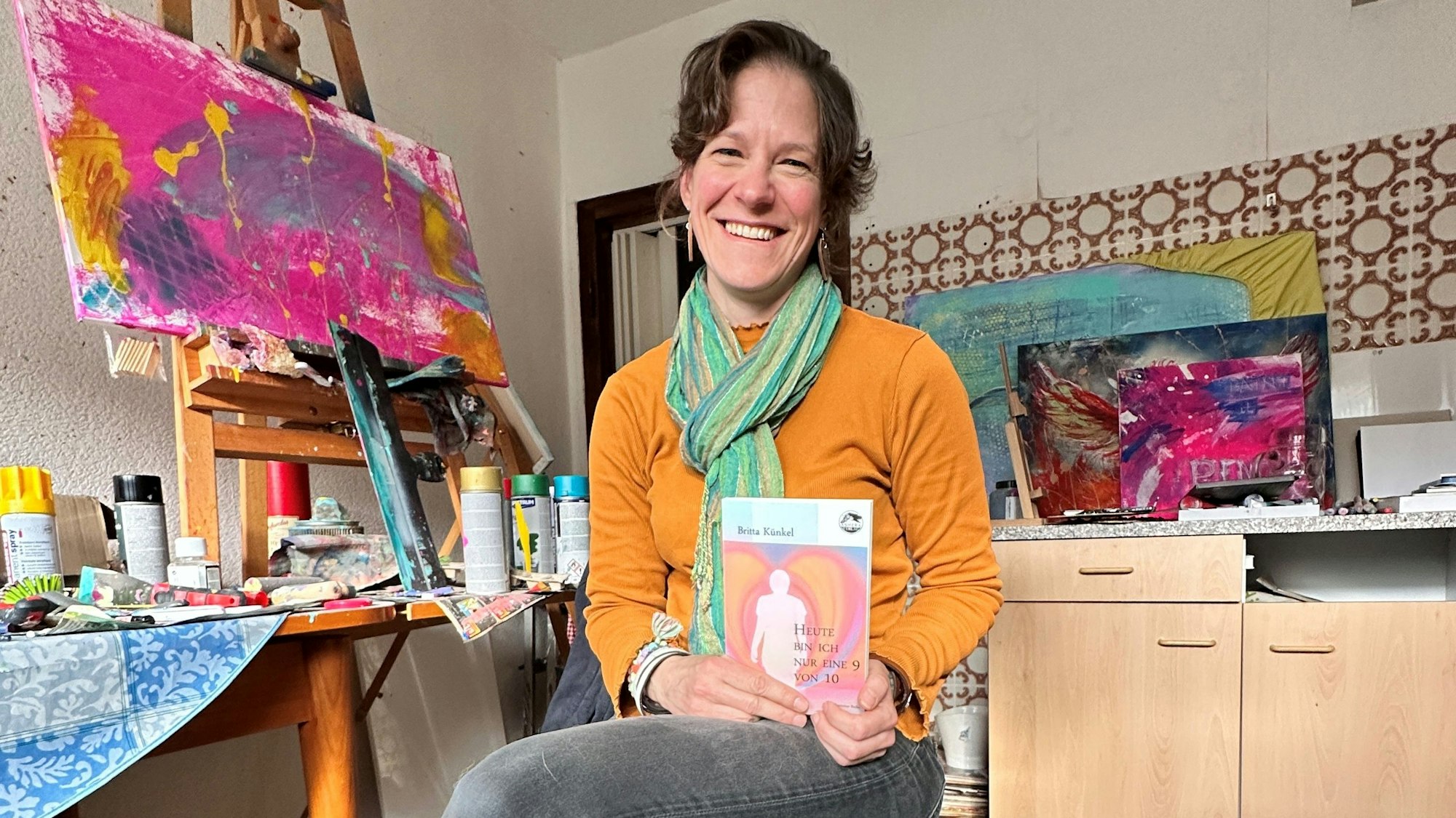 Das Foto zeigt Britta Künkel mit einer Ausgabe ihres ersten Buchs.