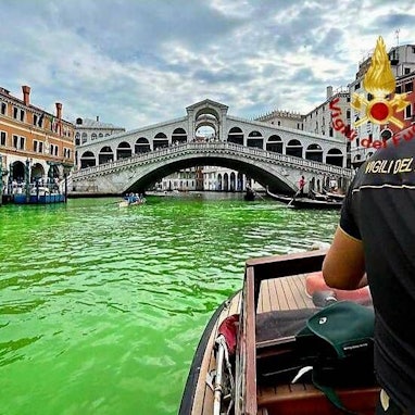 Grün gefärbtes Wasser im Canal Grande von Venedig mit Rialtobrücke und Feuerwehrpräsenz