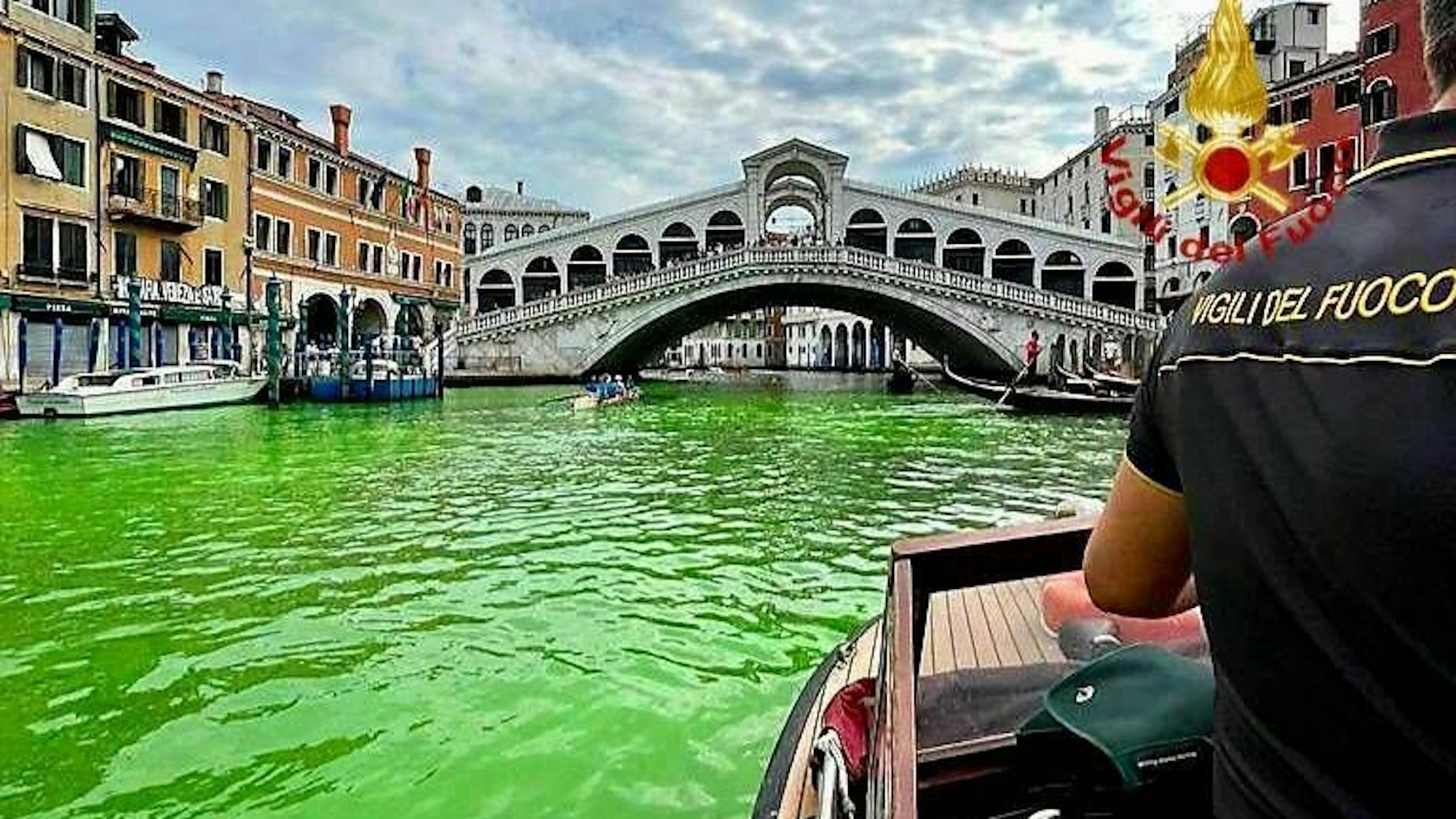 Grün gefärbtes Wasser im Canal Grande von Venedig mit Rialtobrücke und Feuerwehrpräsenz