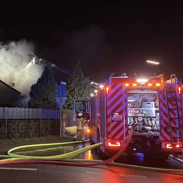 Die Straße „Auf dem Klemberg“ wurde von der Feuerwehr abgesperrt. Im Hintergrund steigen Rauchschwaden auf.