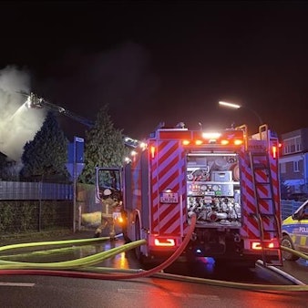 Die Straße „Auf dem Klemberg“ wurde von der Feuerwehr abgesperrt. Im Hintergrund steigen Rauchschwaden auf.
