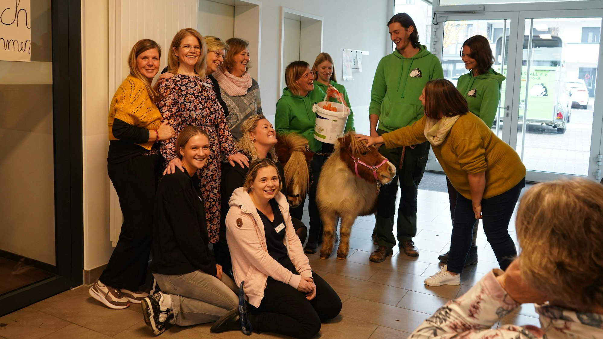 Das Foto zeigt Menschen und zwei Ponys.