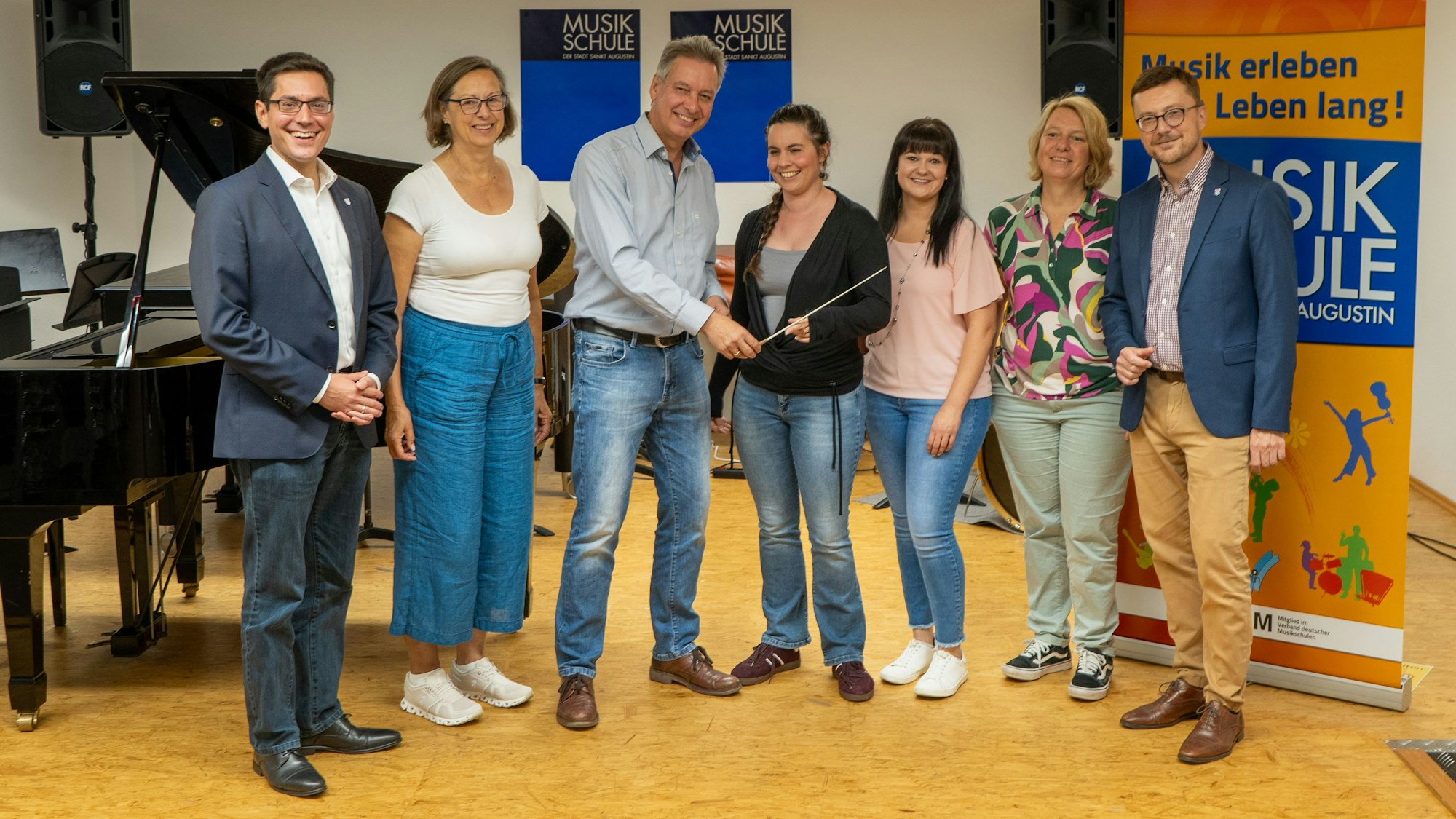 Im Beisein von Bürgermeister Dr. Max Leitterstorf, Martina Kölle, Sandra Fey, Stefanie Will und dem Ersten Beigeordneten Dr. Martin Eßer (v.l.) gab Klemens Salz im vorigen Jahr symbolisch den Dirigentenstab an seine Nachfolgerin Laura Oetzel (Mitte) als Leiterin der Musikschule weiter.