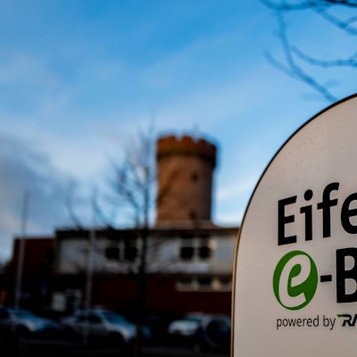 Das Bild zeigt im Vordergrund das Logo des Eifel-E-Bikes, im Hintergrund leicht unscharf die Zülpicher Landesburg.