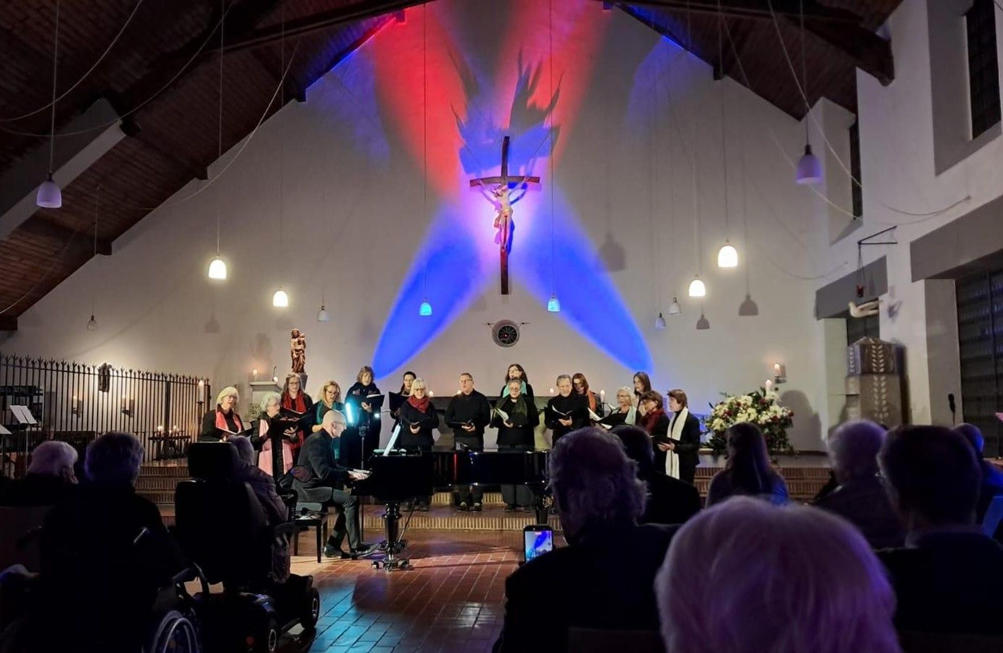 Ein Chor steht in einem Kirchenraum unter einem Kreuz.