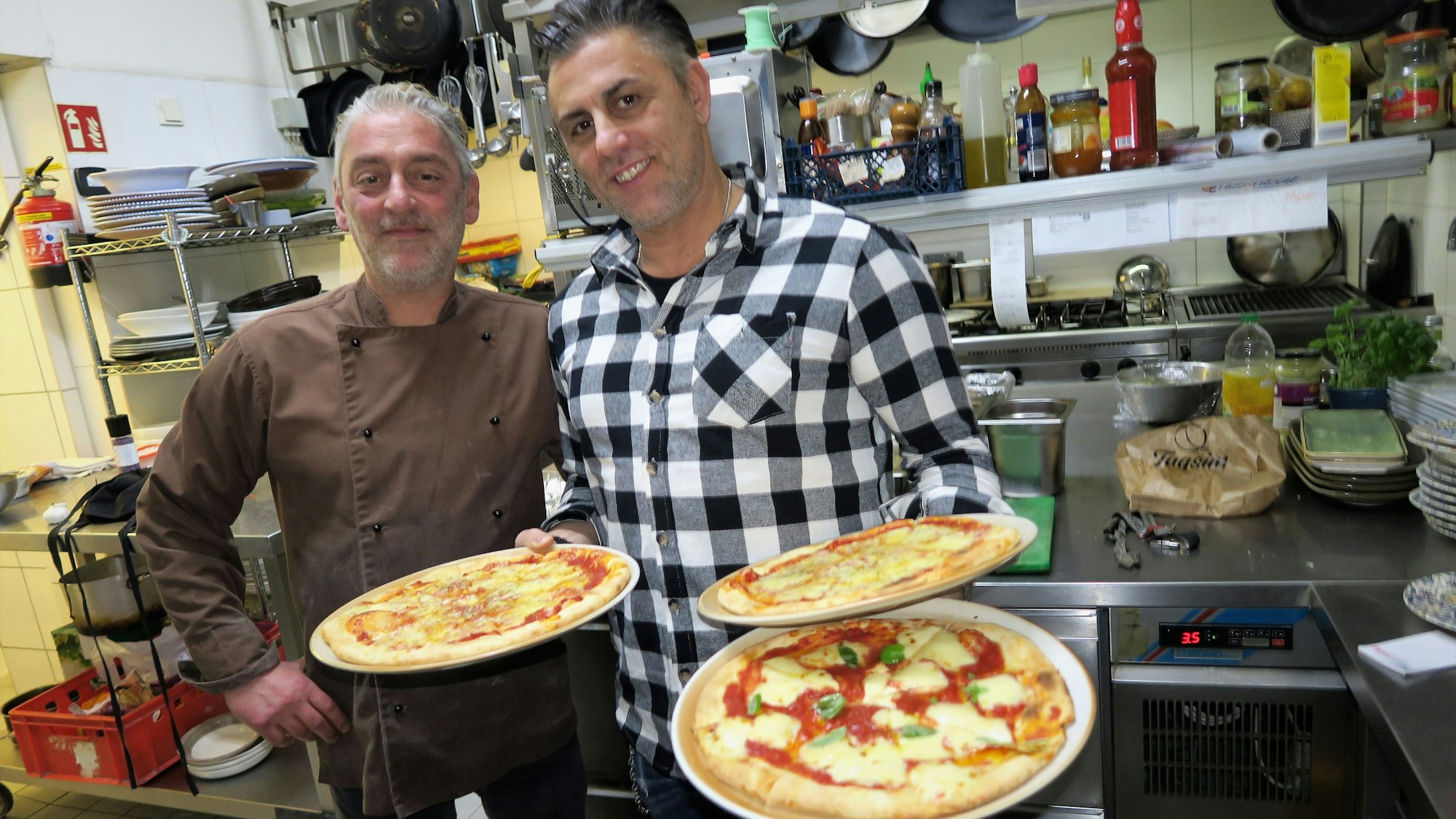 6.2.2023, Brück: Biagio Favazza (r.) und sein Bruder Mario servieren den Kids die Pizza Margeritha. Foto: Hermans