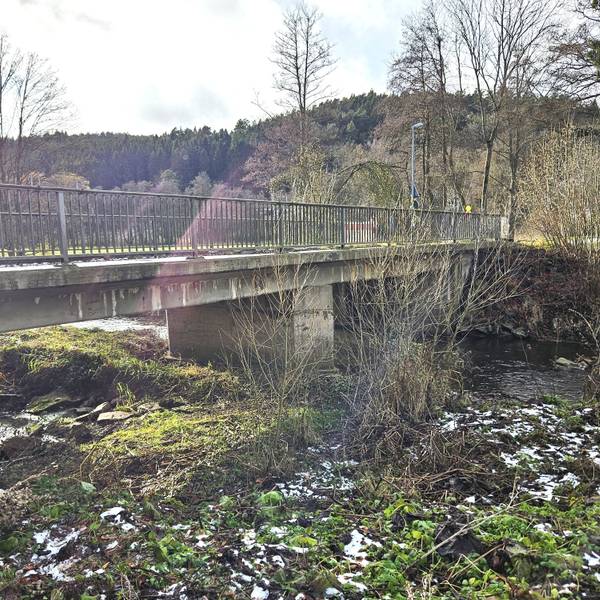 Blick von der Seite auf die alte Brücke, die bei Anstois über die Urft führt.