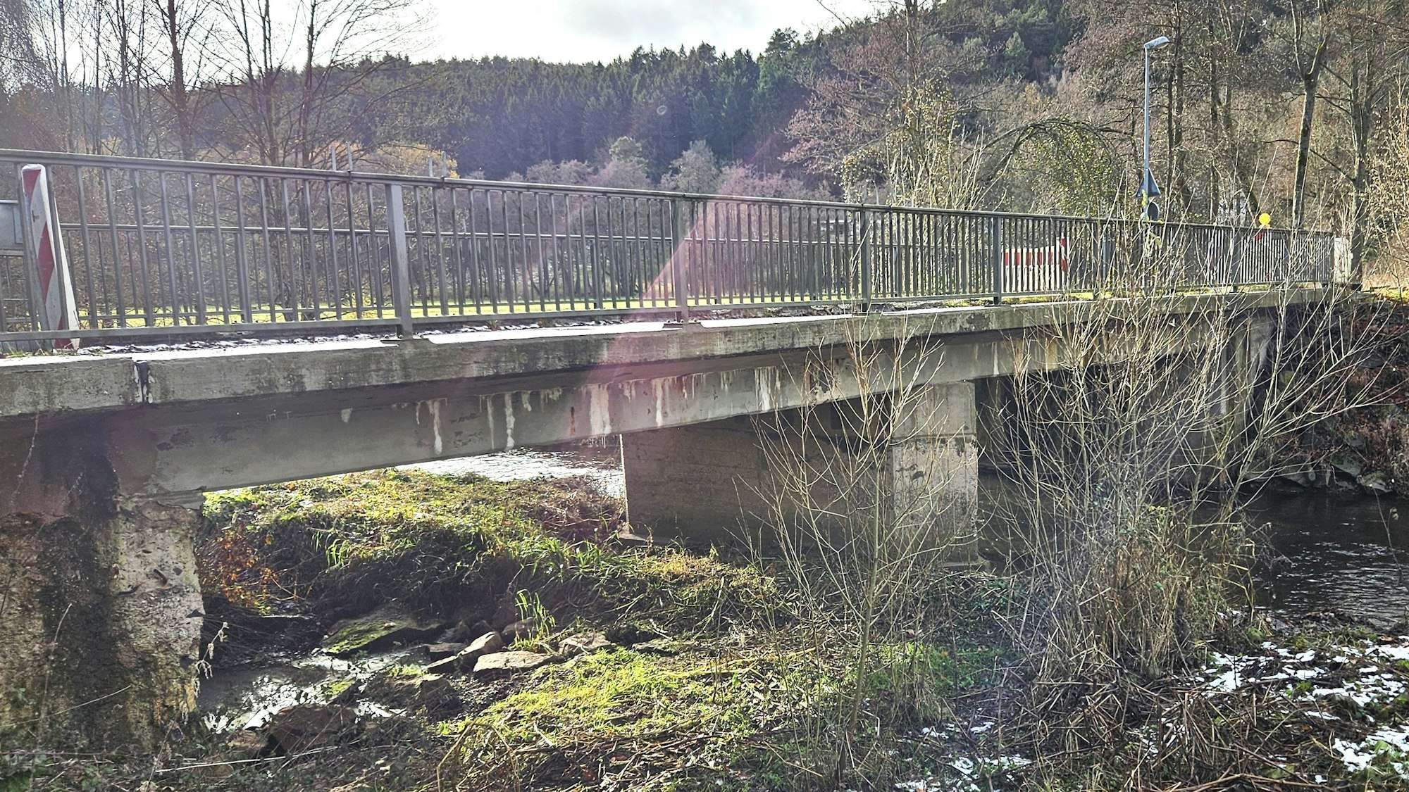 Blick von der Seite auf die alte Brücke, die bei Anstois über die Urft führt.