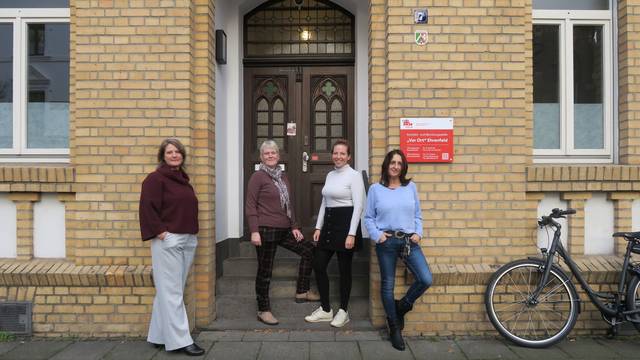 Vier Frauen stehen vor der Tür eines Altbaus.