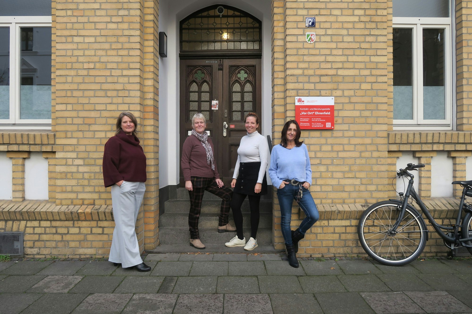 Vier Frauen stehen vor der Tür eines Altbaus.