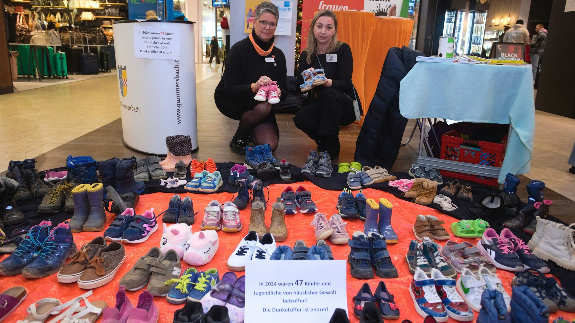 Kinderschuhpaare stehen aufgereiht am Boden im Gummersbacher Forum.