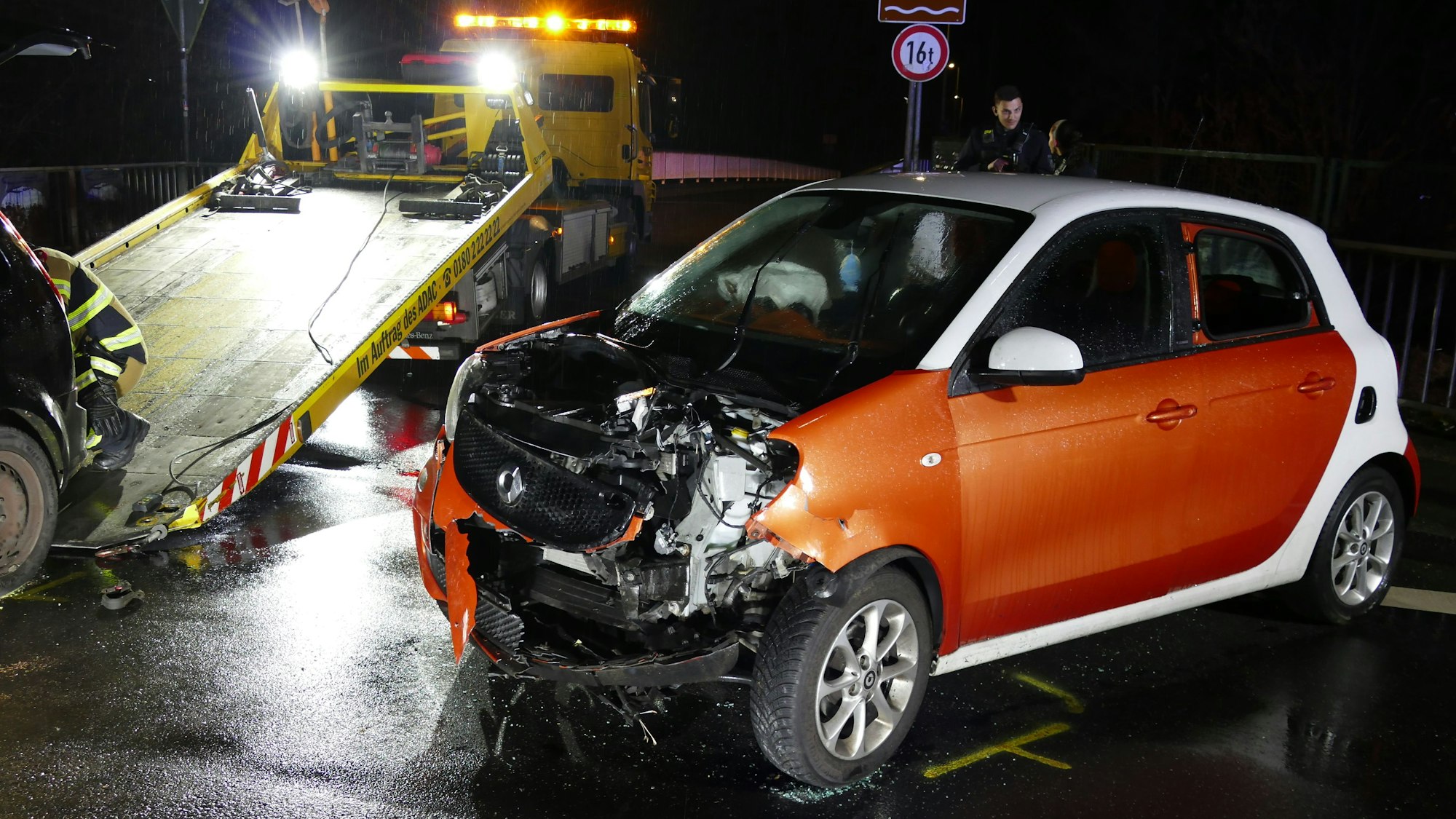 Ein schwer beschädigter Kleinwagen vor einem Abschleppfahrzeug.