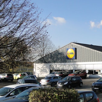 Auf einem Parkplatz vor einem Lidl-Markt stehen viele Autos.