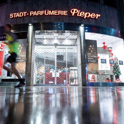 Ein Mann läuft an einer geschlossenen Filiale der Parfümerie Pieper an der Königsallee vorbei.