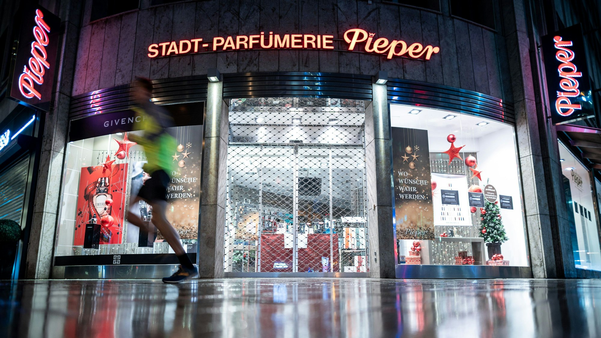 Ein Mann läuft an einer geschlossenen Filiale der Parfümerie Pieper an der Königsallee vorbei.