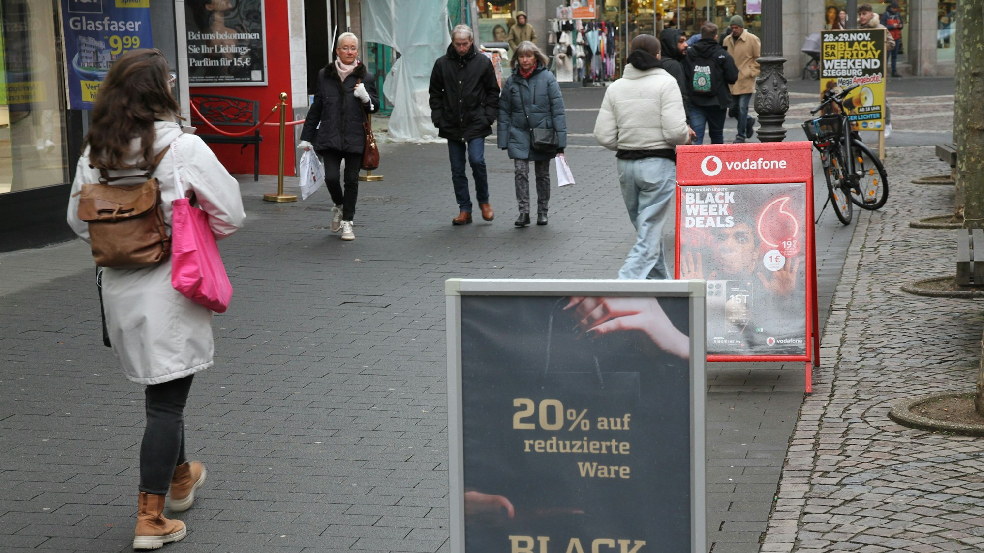 Zum Black Friday wird Kaufsucht besonders zum Thema, Reklameschilder in der Siegburger Fußgängerzone
