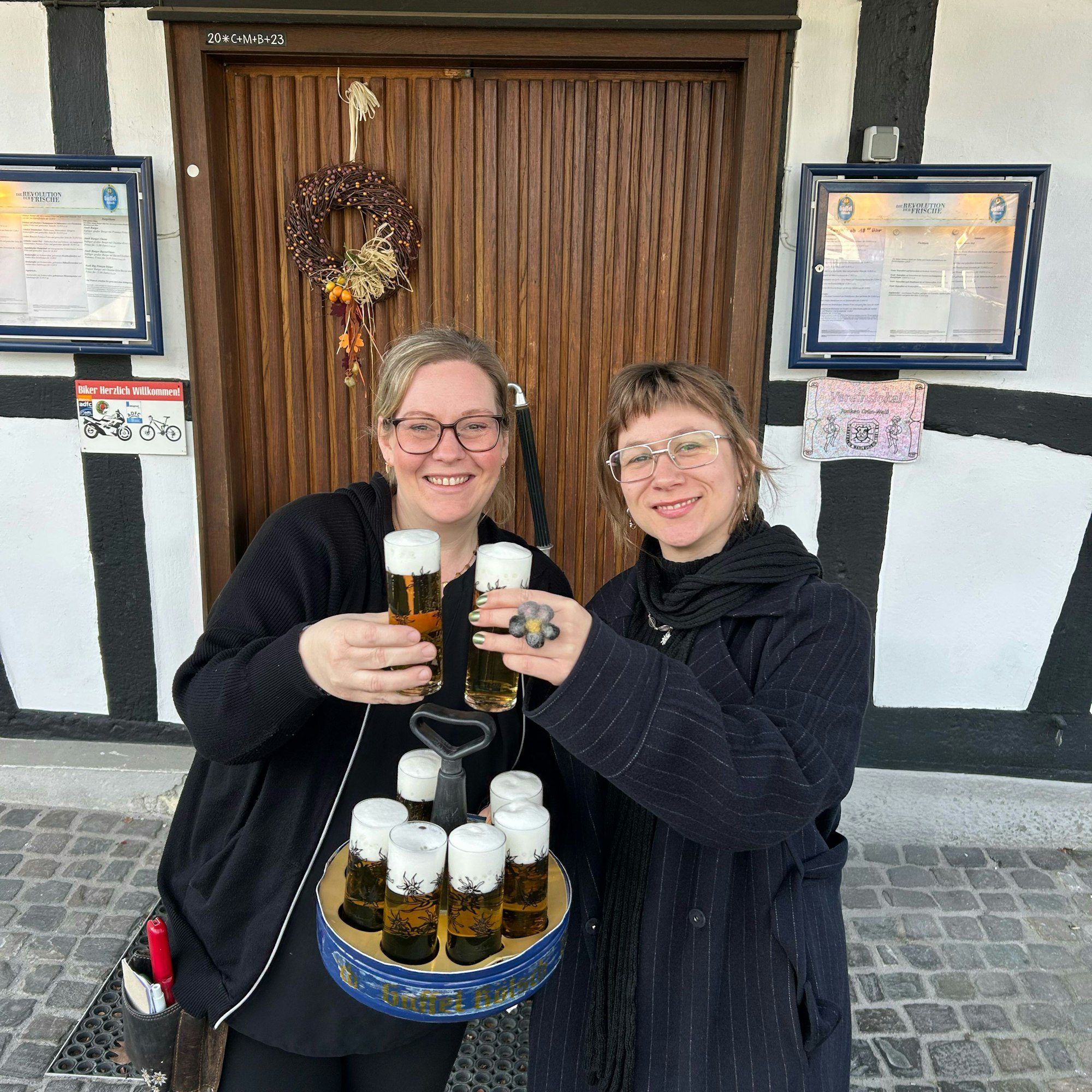 100 Kölsch-Gläser mit politischer Botschaft überreichte die Lohmarer Künstlerin Maja Funke (r.) an Steffi Günther vom Aueler Hof.