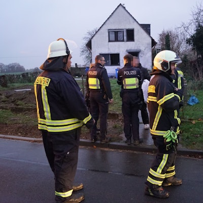 Das Bild zeigt Feuerwehrleute und Polizisten vor dem Einfamilienhaus.