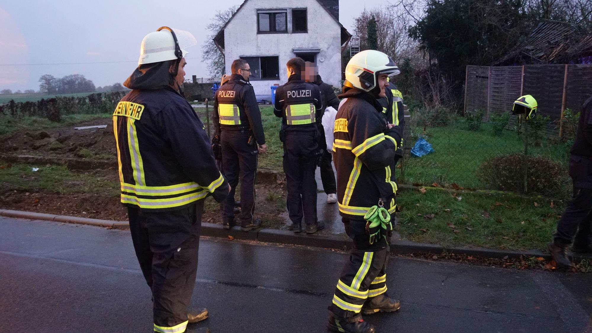 Das Bild zeigt Feuerwehrleute und Polizisten vor dem Einfamilienhaus.
