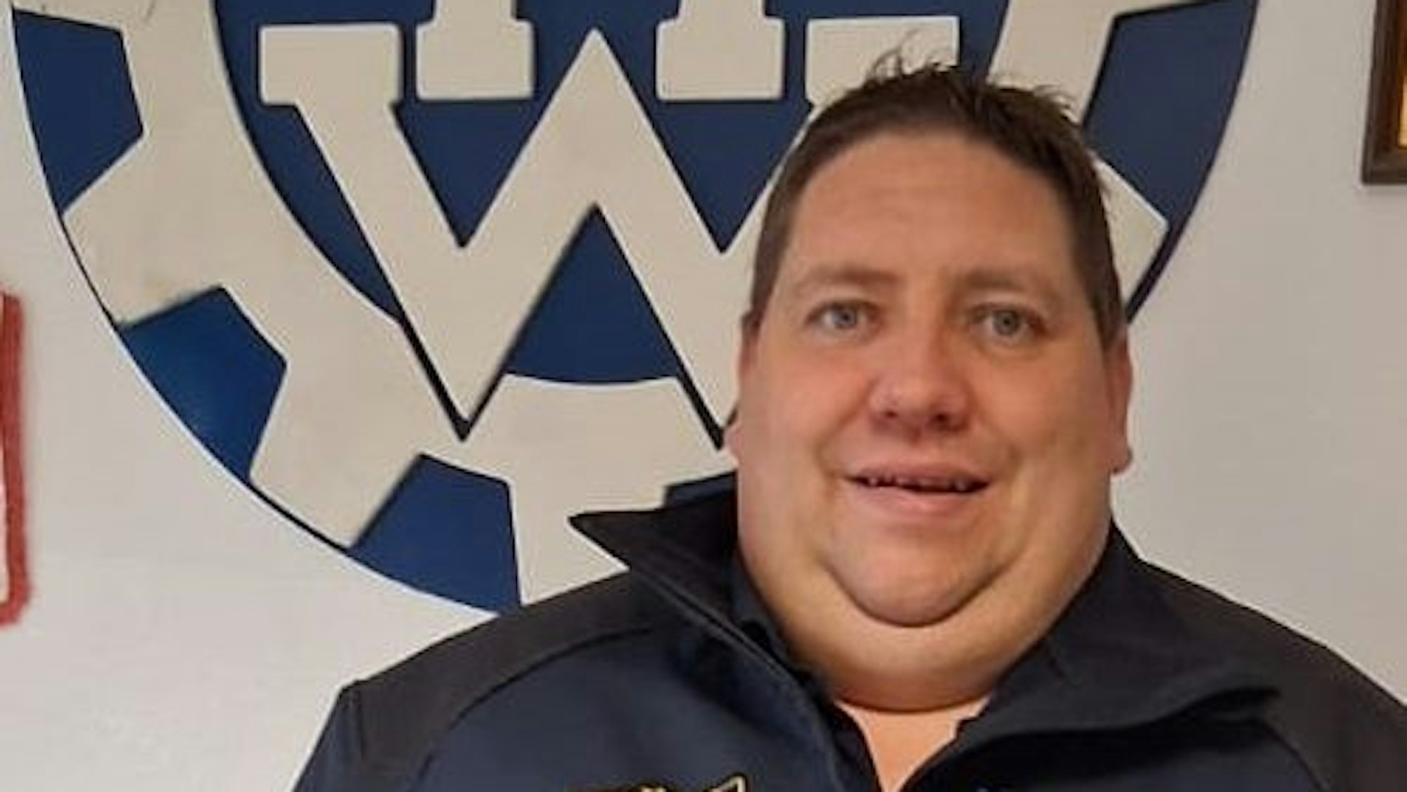 Daniel Schwarzer vor dem THW-Logo.