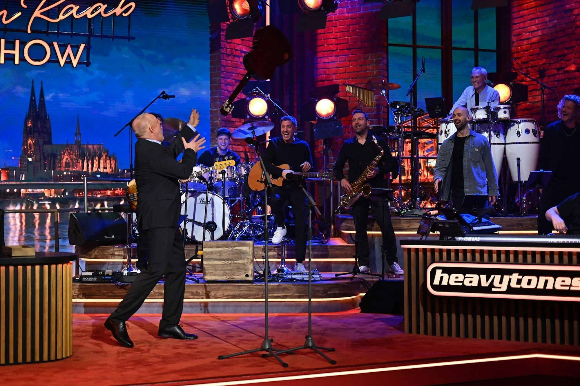 Stefan Raab und ein Bandmitglied werfen die Gitarre hin und her. Mit dem letzten Wurf hatte der Moderator allerdings nicht mehr gerechnet. (Bild: RTL / Raab Entertainment / Julia Feldhagen)