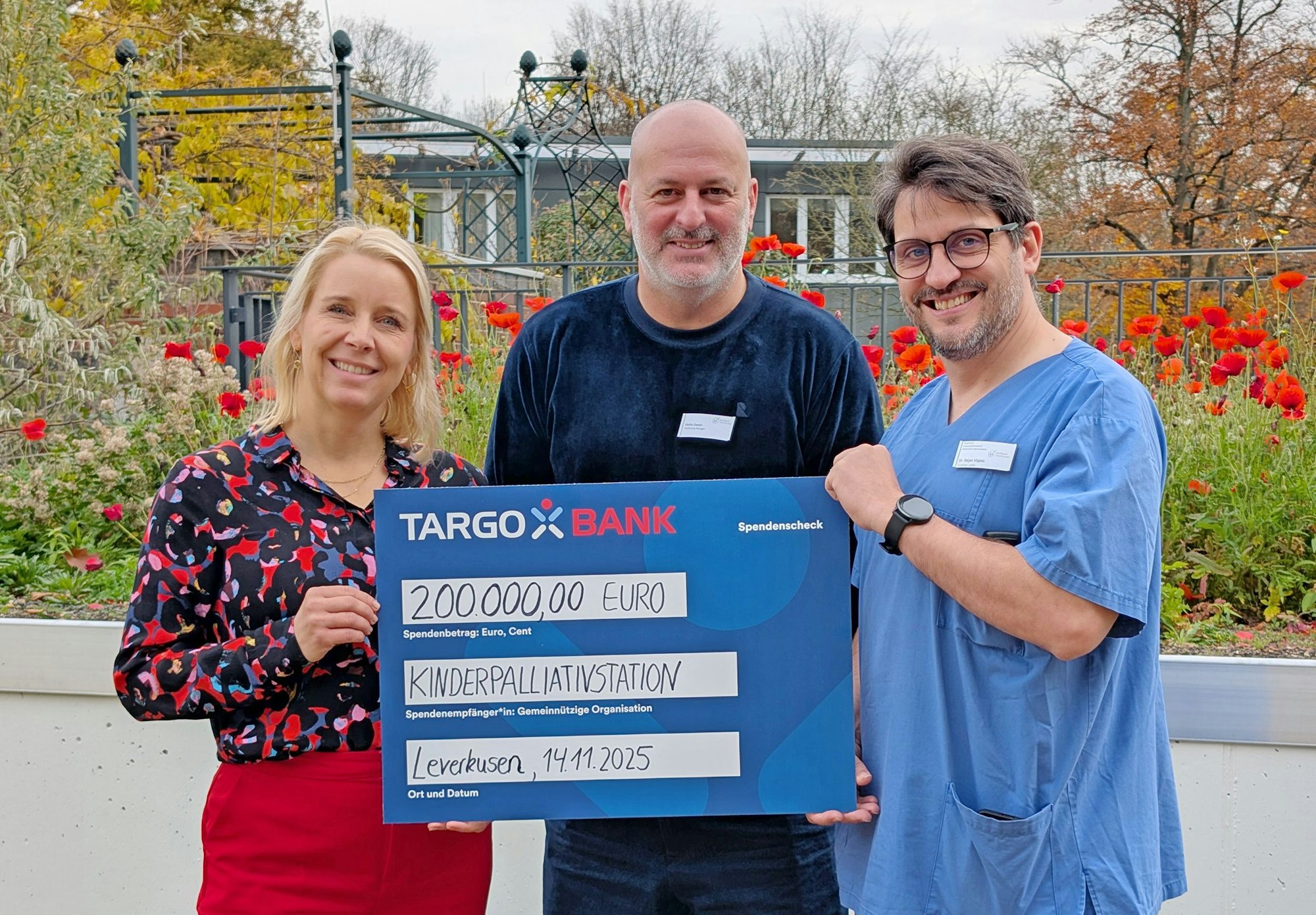 Sonja Glock (l.) von der Targobank überreicht den Scheck an Stefan Daniel (M.) und Dr. Dejan Vlajnic vom Team der Kinderpalliativstation „Zeitinsel“ im Klinikum Leverkusen.