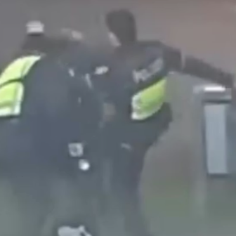 Das Bild zeigt Polizisten, die auf eine Person schlagen und treten.