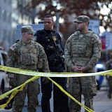 Zwei Nationalgardisten und ein Beamter des Department of Homeland Security sichern in Washington nach einer Schießerei eine Straße.
