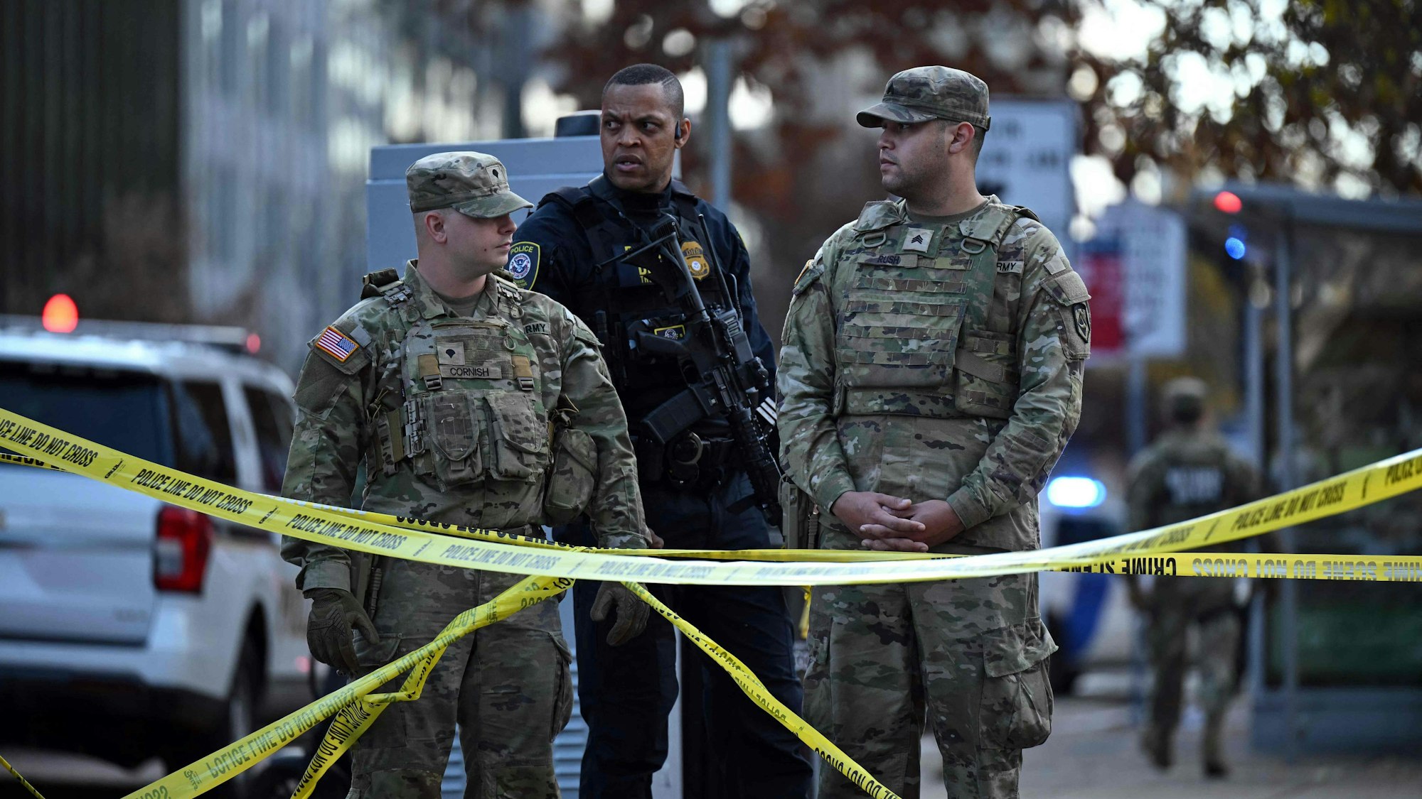 Zwei Nationalgardisten und ein Beamter des Department of Homeland Security sichern in Washington nach einer Schießerei eine Straße.