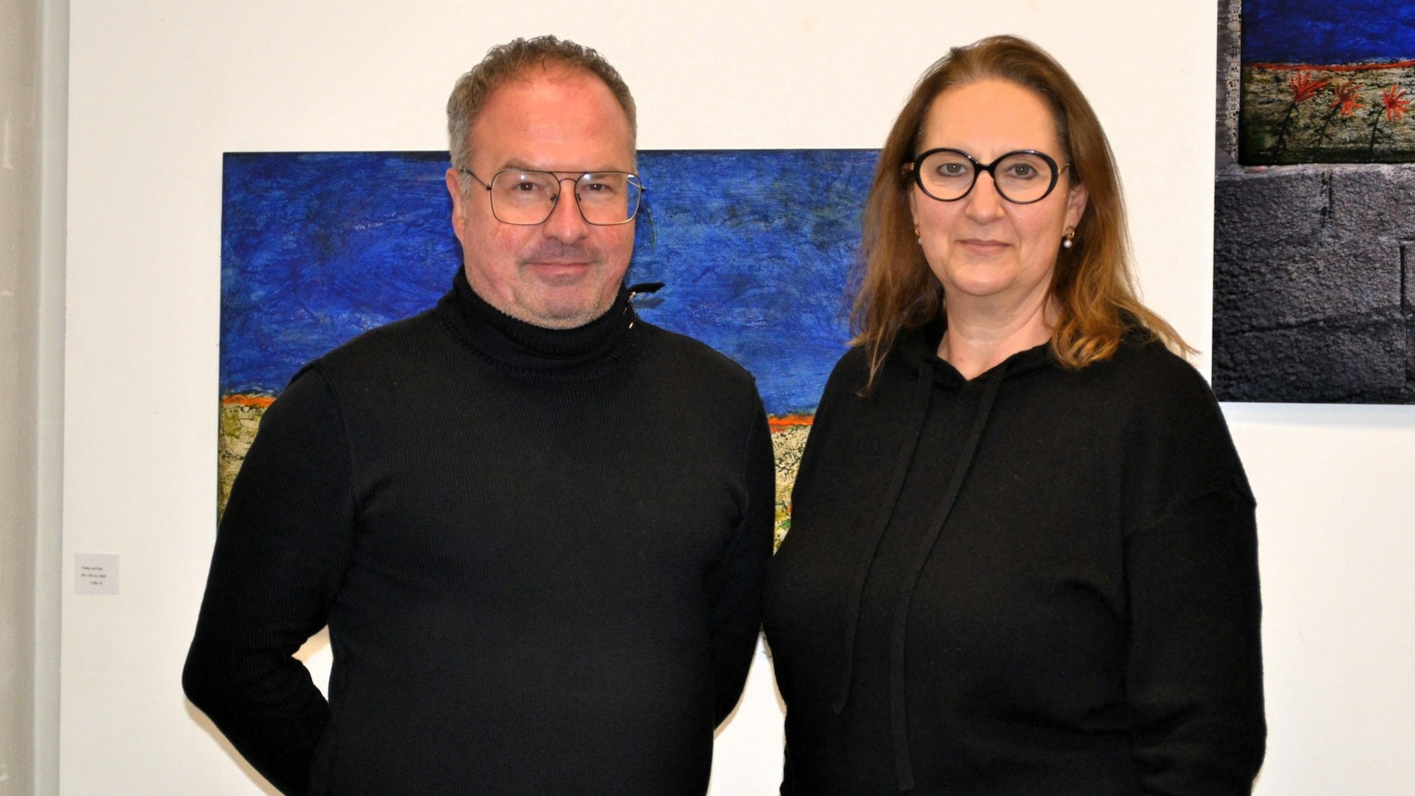 Ein Mann und eine Frau vor einer Wand mit Gemälden
