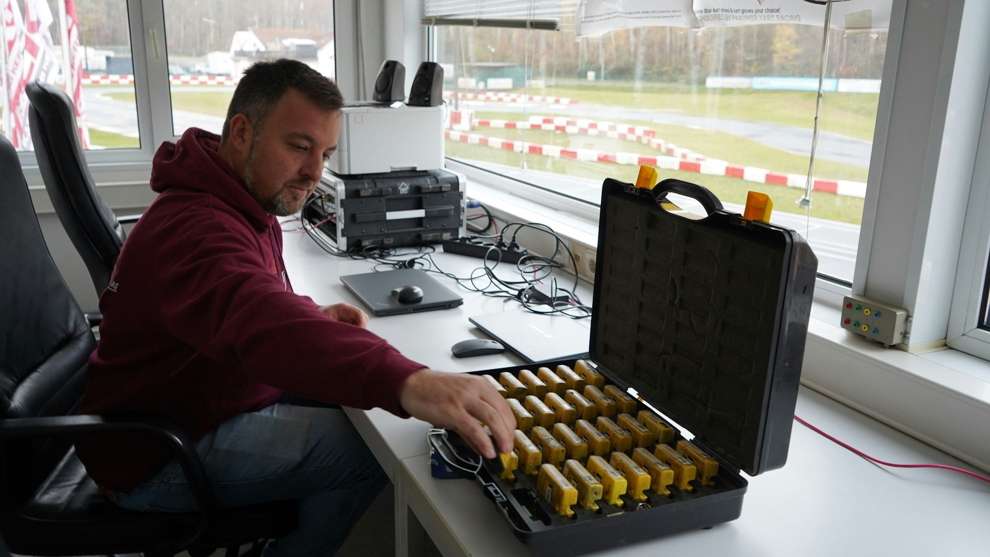 Das Foto zeigt einen Mann, der Transponder aus einem Koffer nimmt.