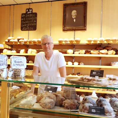Markus Zimmermann ist Chef in der Bäckerei Zimmermann auf der Ehrenstraße. Das Bild an der Wand zeigt seinen Ururgroßvater, der den Betrieb 1875 gründete.