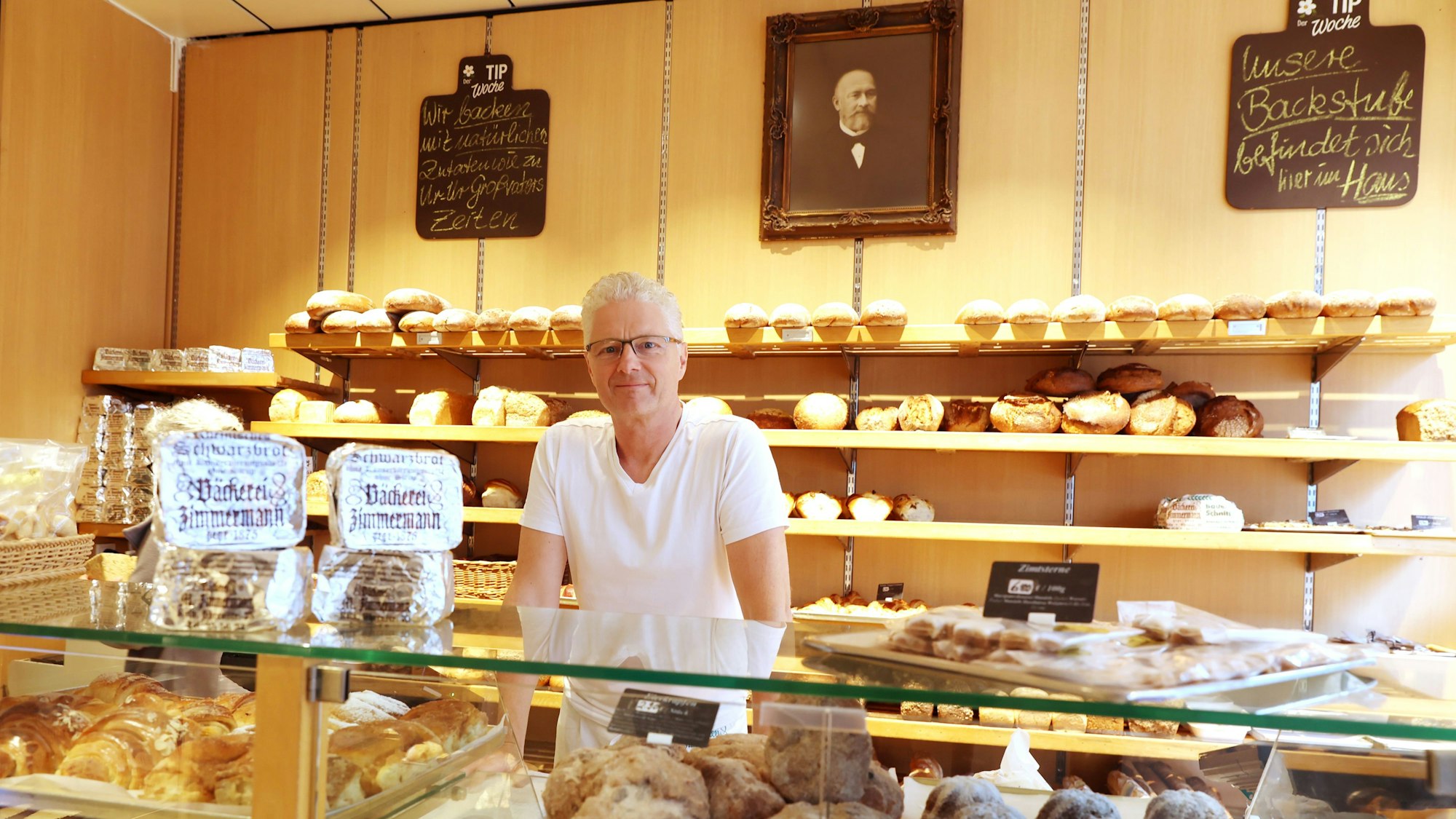Markus Zimmermann ist Chef in der Bäckerei Zimmermann auf der Ehrenstraße. Das Bild an der Wand zeigt seinen Ururgroßvater, der den Betrieb 1875 gründete.