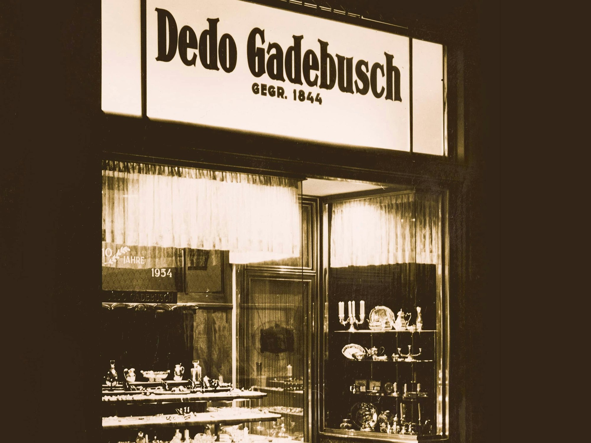 Das Juweliergeschäft in den 1950er Jahren noch unter dem Namen Dedo Gadebusch. Im Fenster stehen Silberleuchter und -teller.