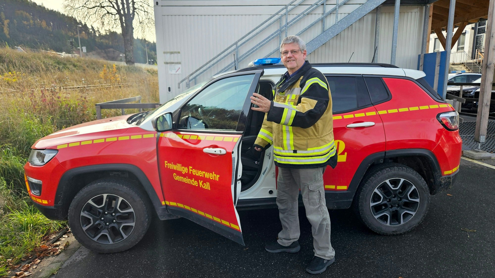 Harald Heinen steht vor seinem Einsatzwagen, die Fahrertür ist geöffnet.