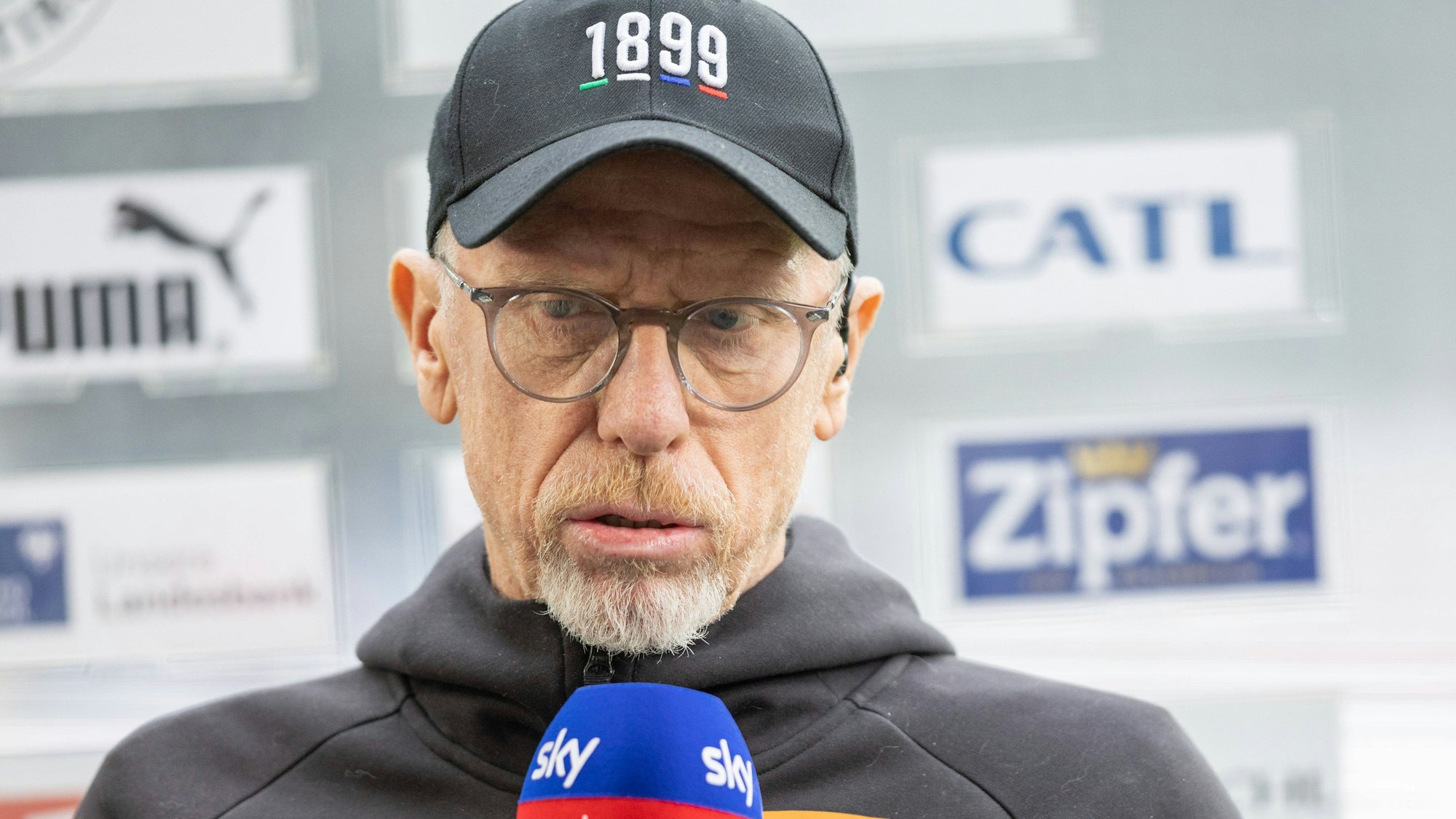 Peter Stöger mit Sky-Mikrofon unterm Kinn.