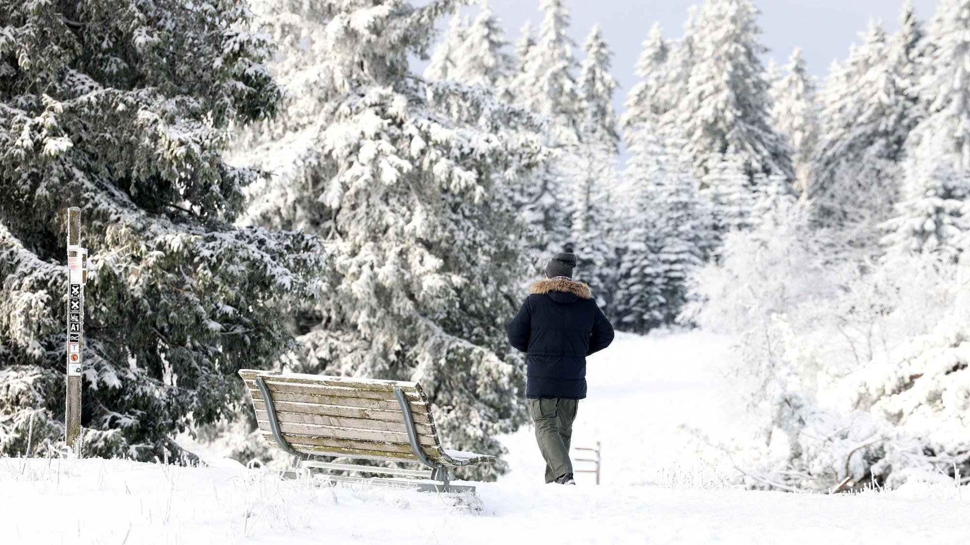 Ein Mann geht durch die verschneite Landschaft am Kahlen Asten.