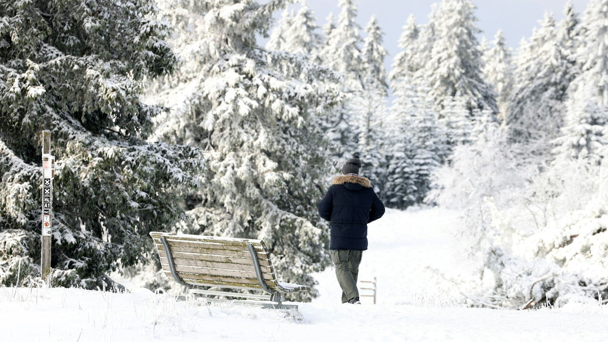 Ein Mann geht durch die verschneite Landschaft am Kahlen Asten.