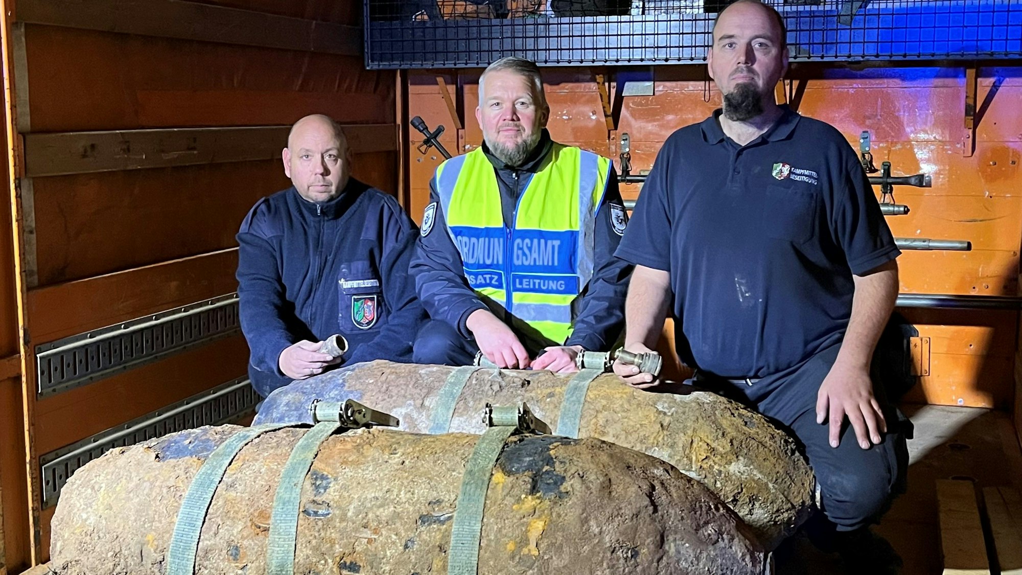 Dirk Schmitz (KBD), Richard Berdel (Einsatzleitung Ordnungsamt) und Markus Schmitz (KBD) stehen neben den beiden entschärften Blindgängern.