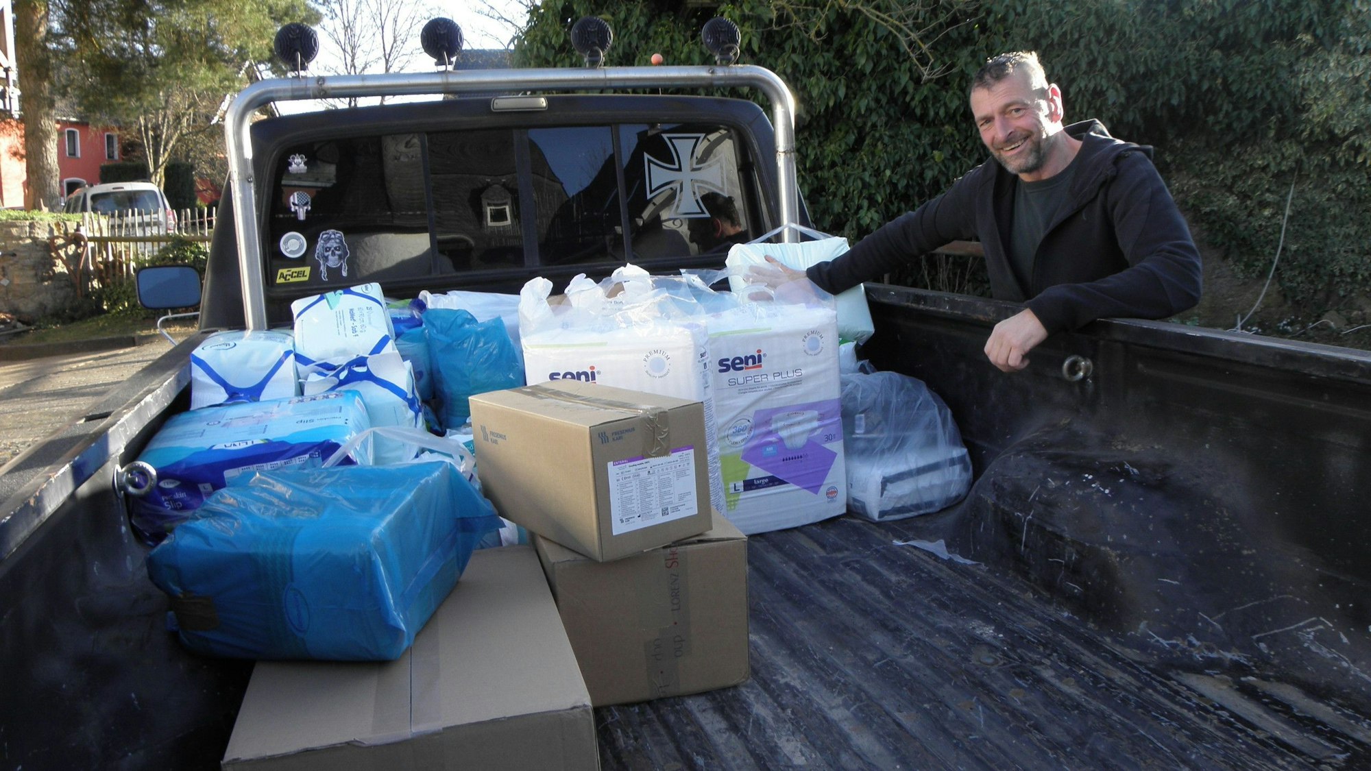 Das Bild zeigt Thomas Claßen, der Hilfsgüter auf einer Ladefläche verstaut.