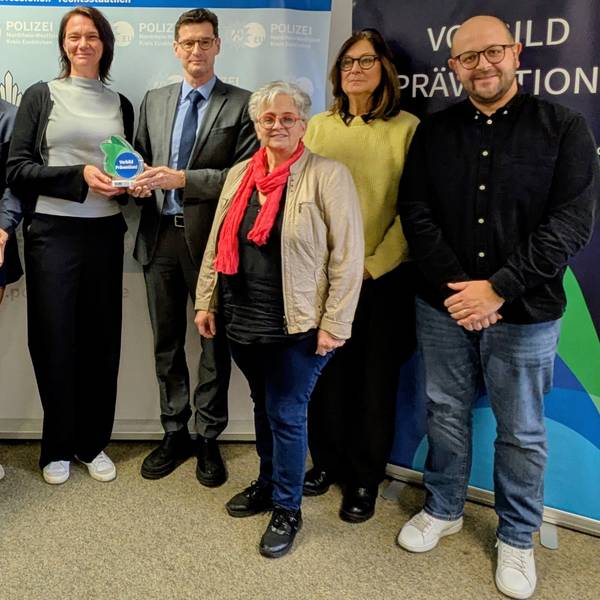 Auf einem Gruppenfoto präsentieren die Beteiligten die Trophäe und die Urkunde.