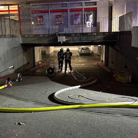 Ein Feuerwehrmann in voller Montur in einer verrauchten Tiefgarage.