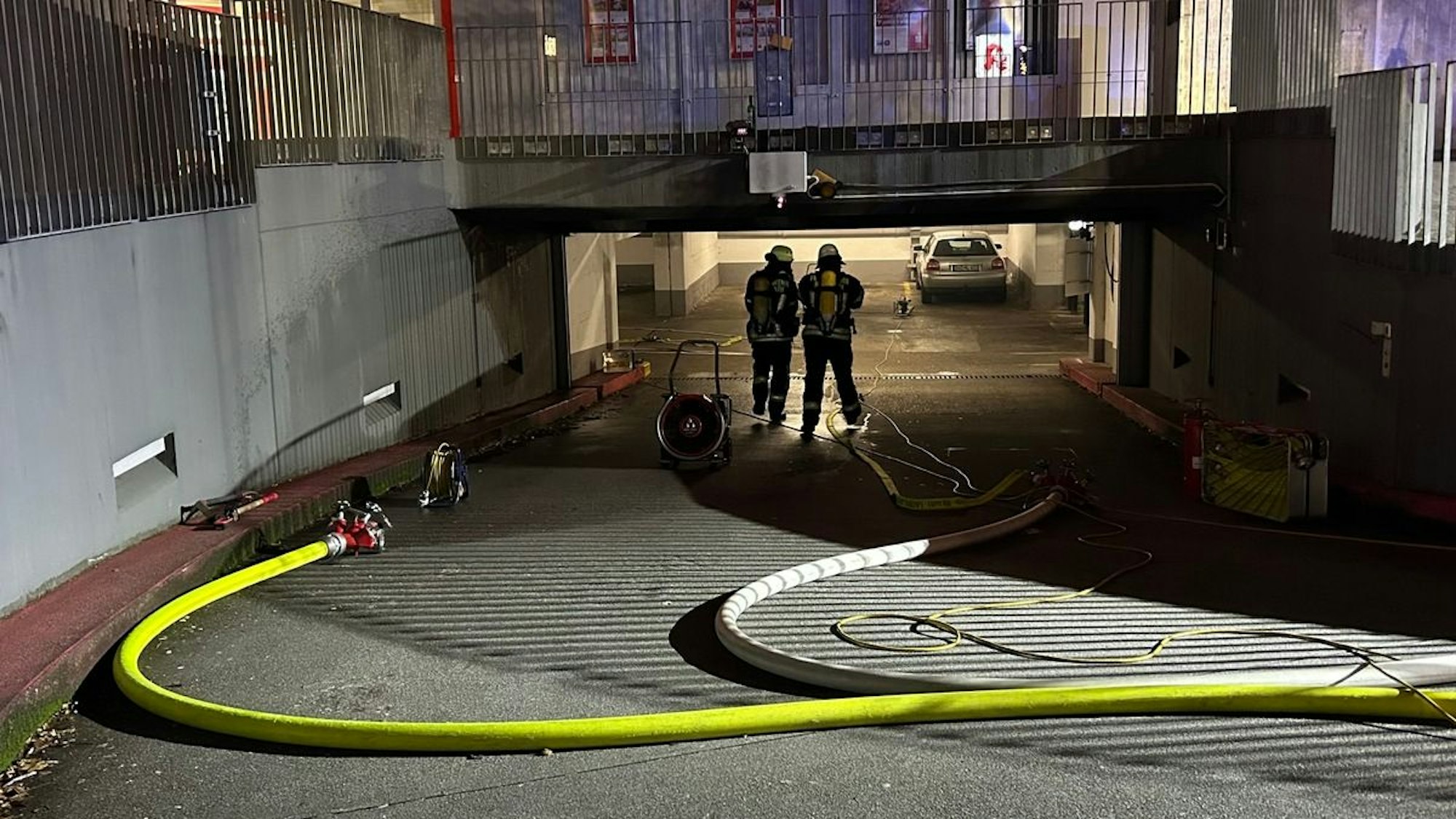 Ein Feuerwehrmann in voller Montur in einer verrauchten Tiefgarage.