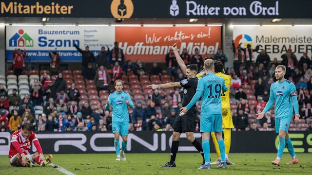 Schiedsrichter Timon Schulz zeigt auf den Elfmeterpunkt und Viktorias Florian Engelhardt (nicht im Bild) die Rote Karte.