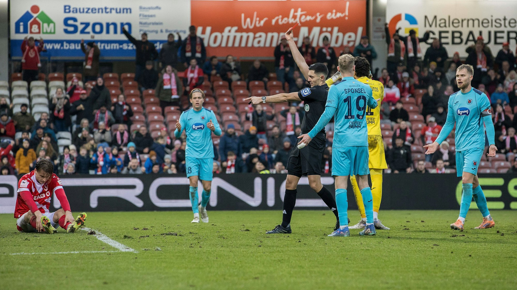 Schiedsrichter Timon Schulz zeigt auf den Elfmeterpunkt und Viktorias Florian Engelhardt (nicht im Bild) die Rote Karte.
