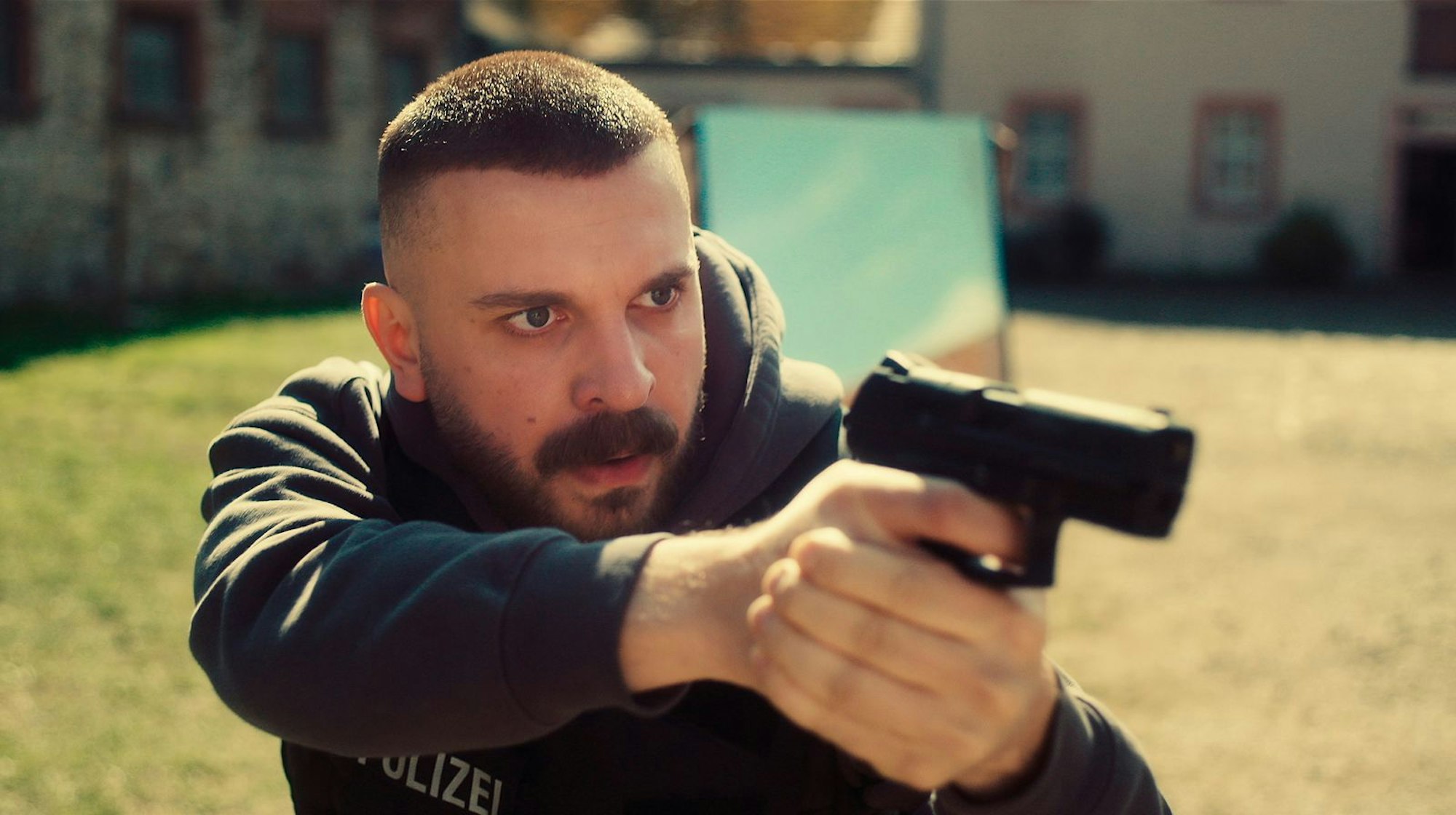 Hamza Kulina (Edin Hasanovic) sichert einen Hof, bei dem man nicht weiß, wer sich dort herumtreiben könnte. (Bild: HR/Sommerhaus/Tatiana Vdovenko)